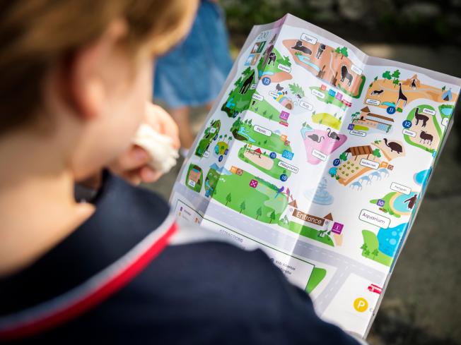 Child holding synthetic paper Teslin map